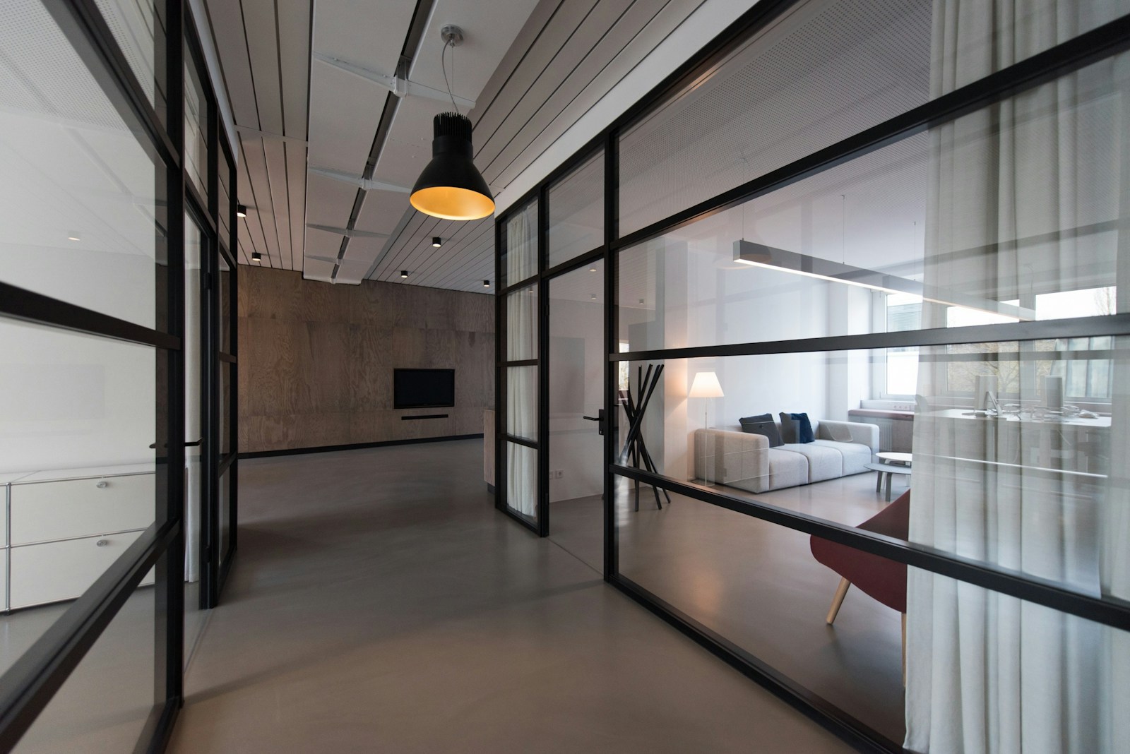 Modern office corridor with meeting rooms and natural light